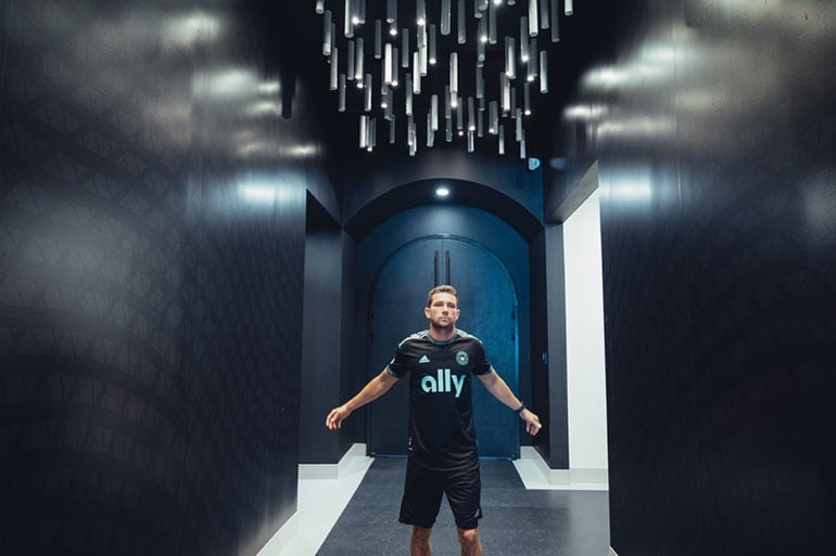 Brandt Bronico poses in the hallway in front of the Charlotte FC locker room