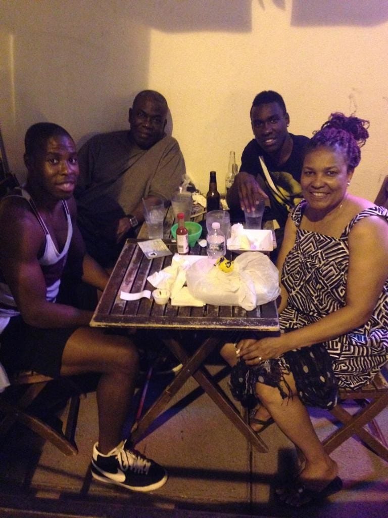 Sam and three family members seated at a restaurant table for dinner