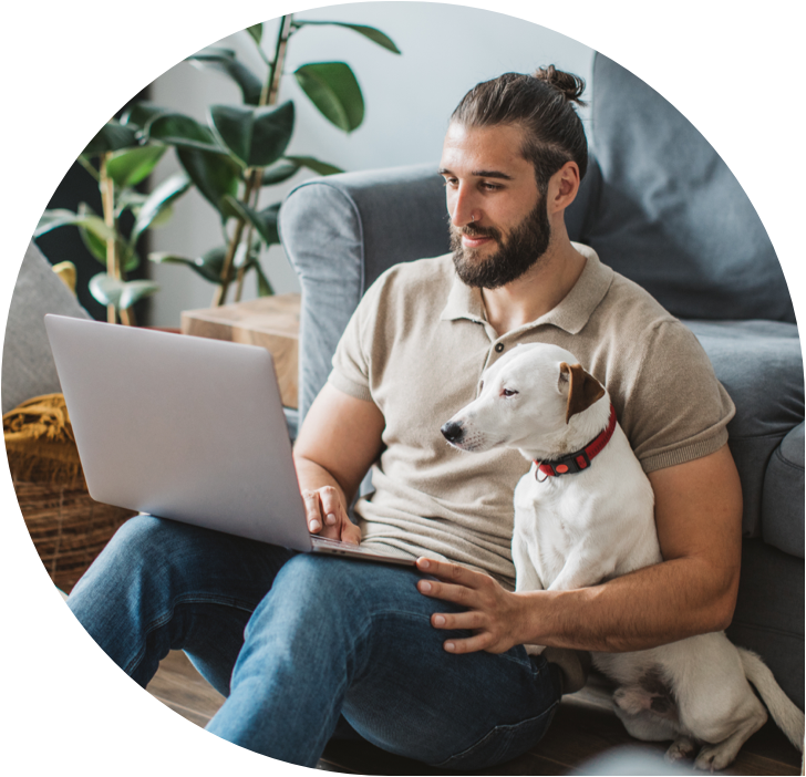 Photo of man working on laptop with dog