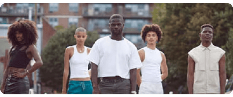 Five business owners with dark skin pose outside and address the camera.