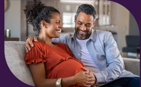 A man with his hand on his pregnant wife's stomach