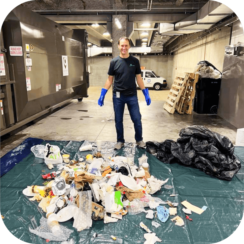 A man standing in front of a pile of trash.