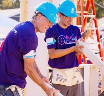 Two male Ally employees volunteering at a building site.