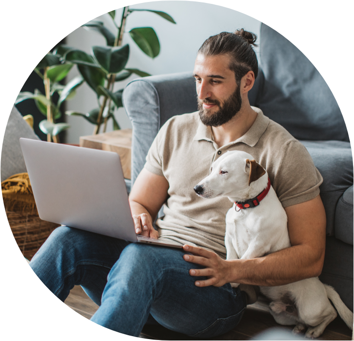 Photo of man working on laptop with dog