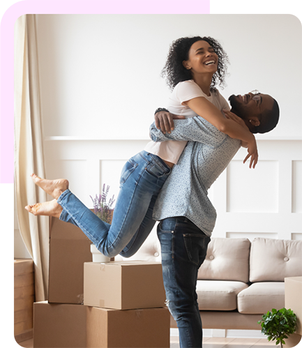 a man lifting up a woman in a living room surrounded by moving boxes