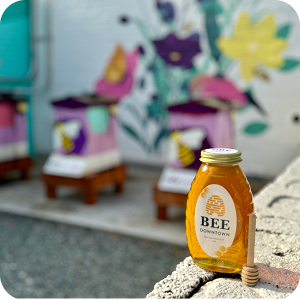 A jar of honey is posed on a concrete wall outside of Envision Charlotte’s Innovation Barn.