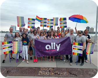 a group of volunteers celebrating pride while holding an Ally do it right banner