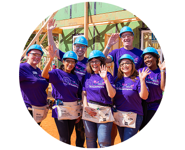 A group smiling Ally employees voulenteering at a Habitat for Humanity site.
