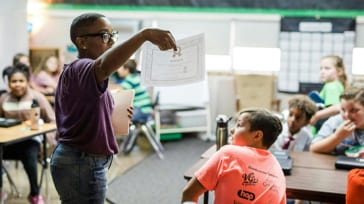 An Ally employee gives a lesson to school children.