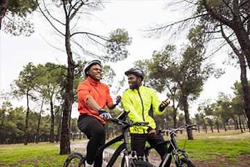 Two men ride bikes on a trail