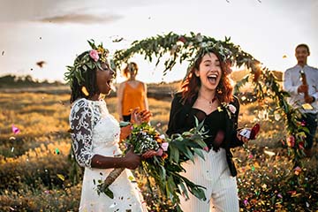 Two brides celebrating after their outdoor ceremony