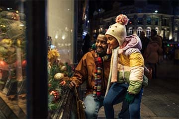 Dad and daughter go window shopping during the holiday season