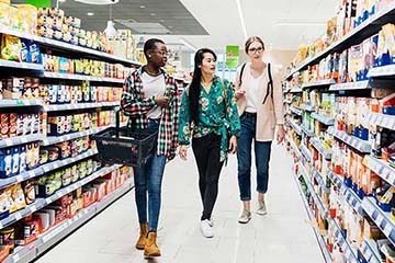 Three girls shopping in supermarket