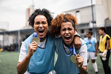 Female soccer players celebrate a gold medal win.