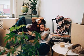 A happy couple taking selfies in their new home.