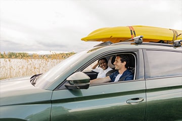 A couple smiling while driving to the lake.