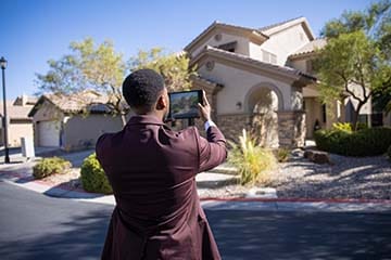 Man taking picture of a house.