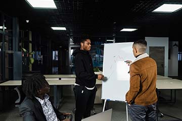 Group of businessmen discussing business at a whiteboard.