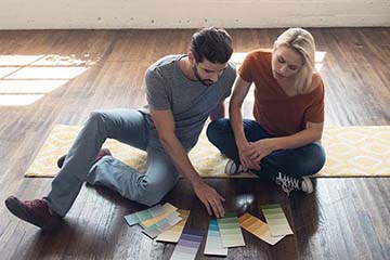 Young couple sitting on the floor looking at plans for their home