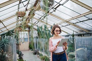 earcher on a tablet in a greenhouse