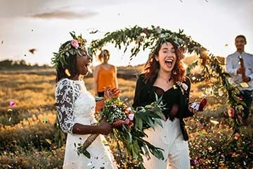 Two brides celebrating after their outdoor ceremony