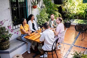 Image of friends gathered around a table in a courtyard
