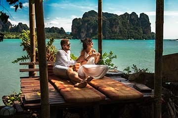 Man and woman relax in cabana by the water