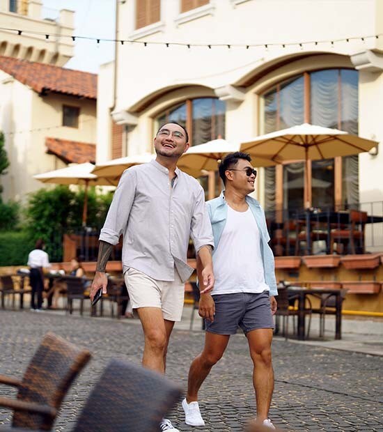 Two men happily walk through a vacation town