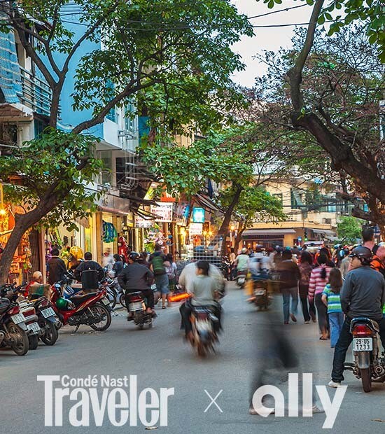 Bustling street in Hanoi, Vietnam, lined with vendors and motorcycles.
