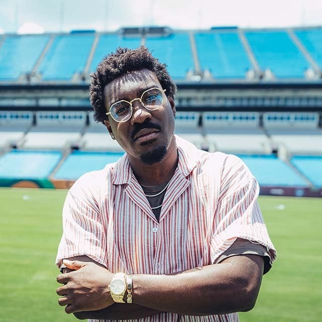 Charlotte FC commentator Lloyd Sam stands on the field at BOA stadium
