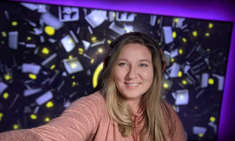 Heather Garozzo posing in front of a patterned background wearing headphones